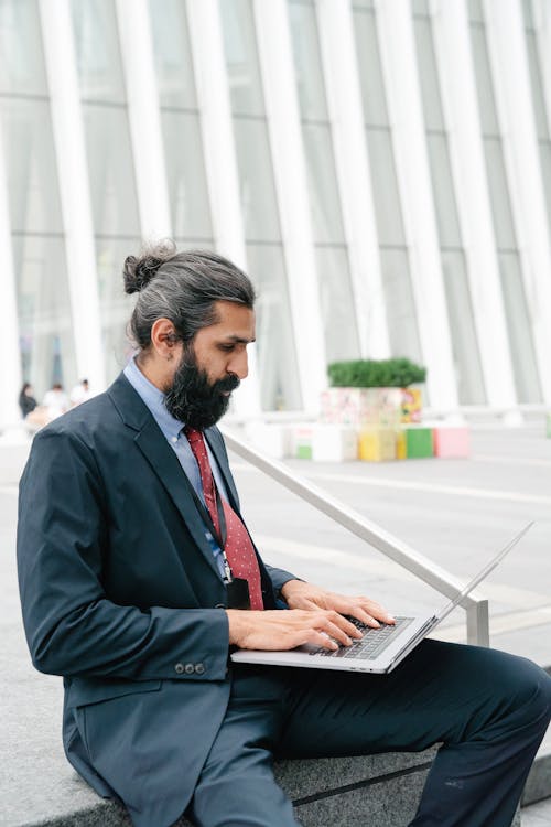 Free Man in Business Attire typing on his Laptop  Stock Photo