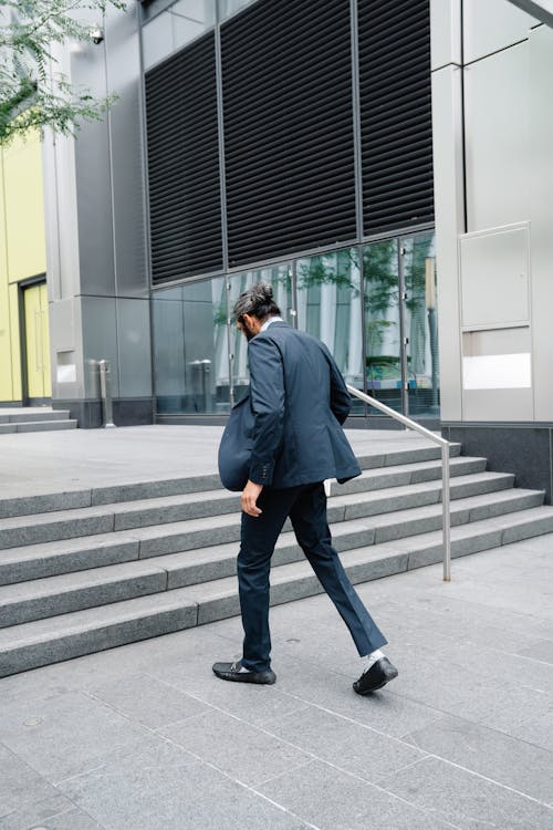 Man in Full Suit walking Towards Staircase