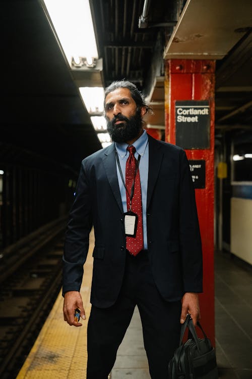 Free Man in Business Attire standing on Subway Platform Stock Photo