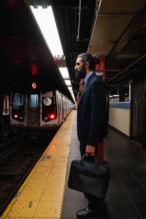 Free Man in a Suit standing on a Subway Platform  Stock Photo