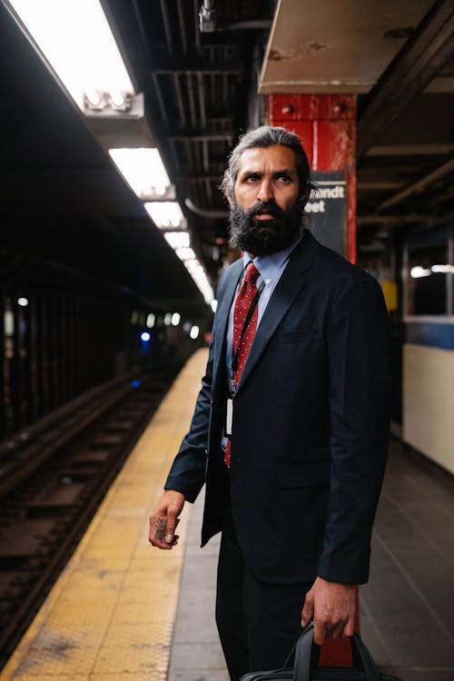 Man in a Suit standing on a Subway Platform 