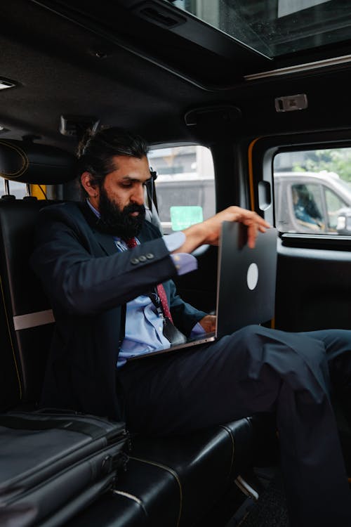 Businessman using Laptop inside Car 