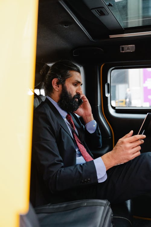 Businessman talking on Phone while looking at his Laptop 