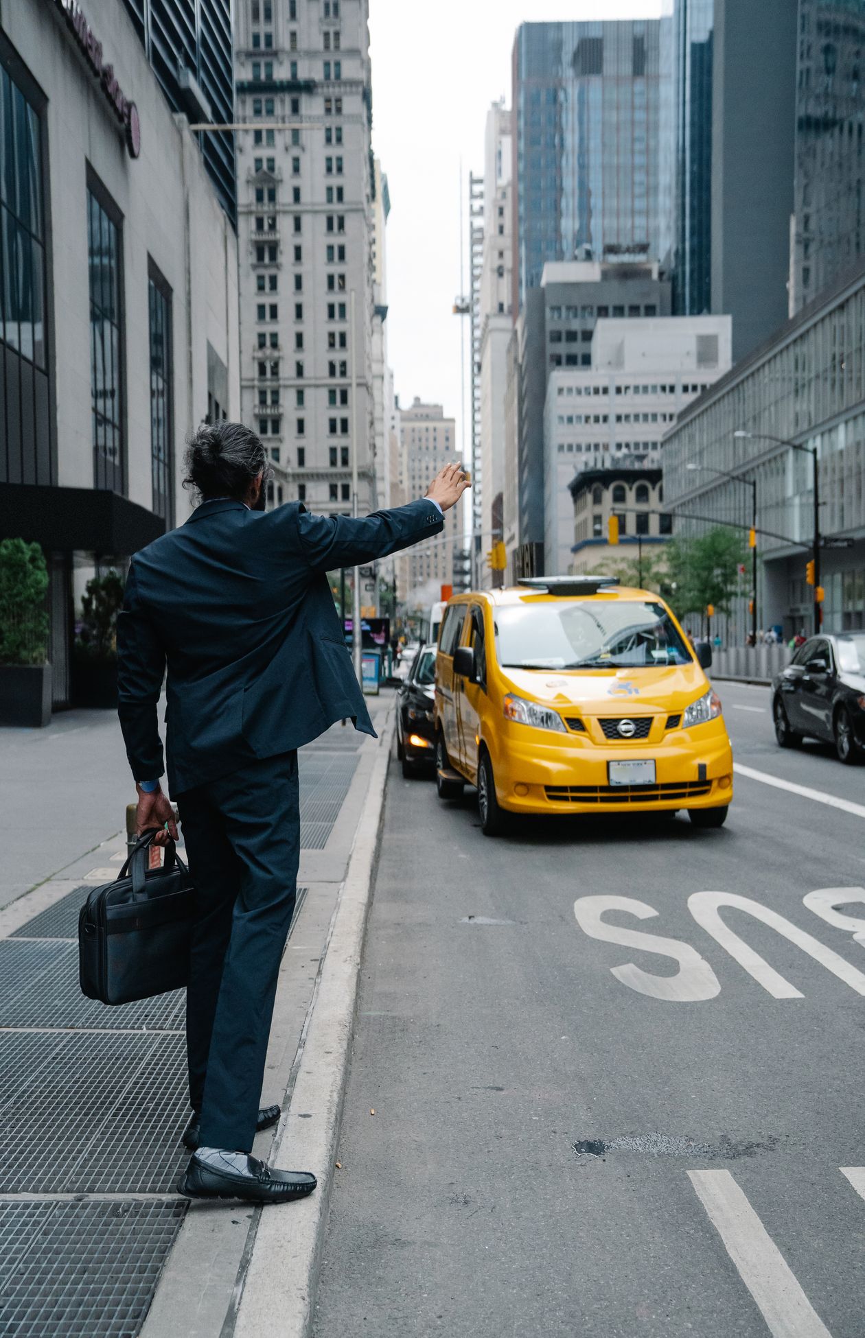 Businessman hailing a taxi on a city street