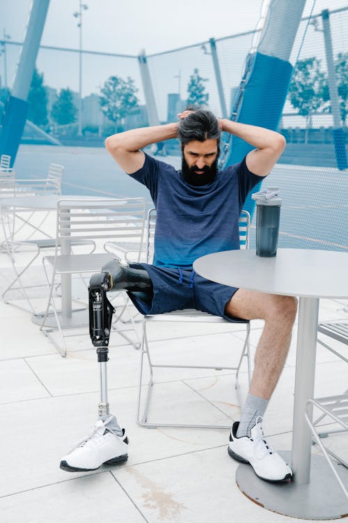 Free Man with Prosthetic Limb sitting on Chair Stock Photo