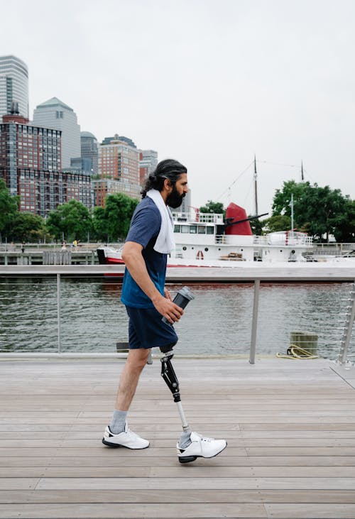 Sportsman with Prosthetic Leg walking on Wooden Footpath 