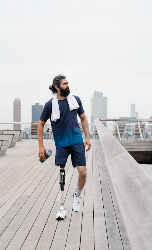 Sportsman with Prosthetic Leg walking Down on Footbridge