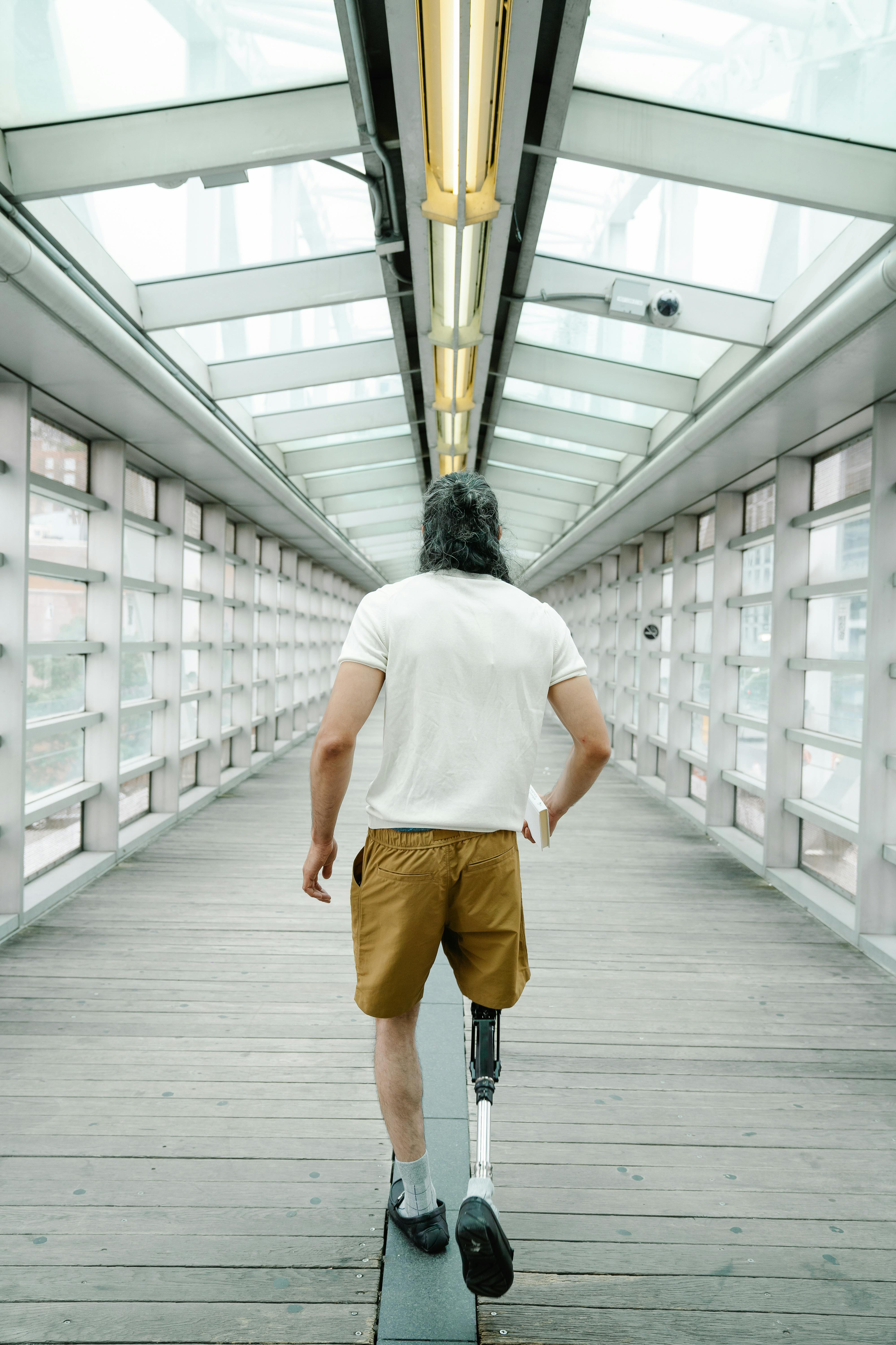 Free Man with Prosthetic Leg walking on a Wooden Footpath Stock Photo