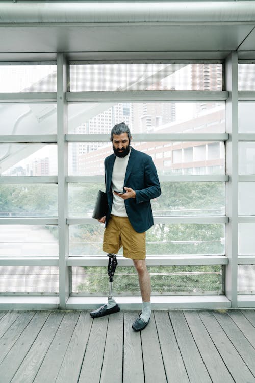 Man with Prosthetic Leg looking at his Phone