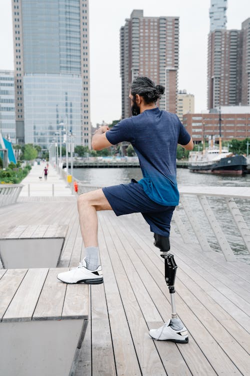 Man with Prosthetic Leg Exercising on Wooden Platform 