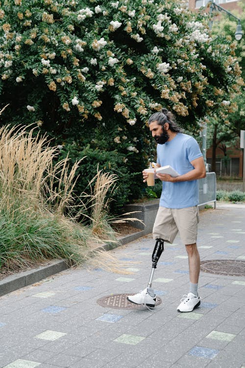 Man with Prosthetic Leg carrying Iced Coffee