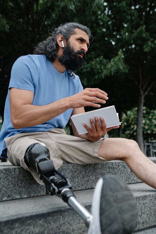 Man with Prosthetic Leg seated on Staircase