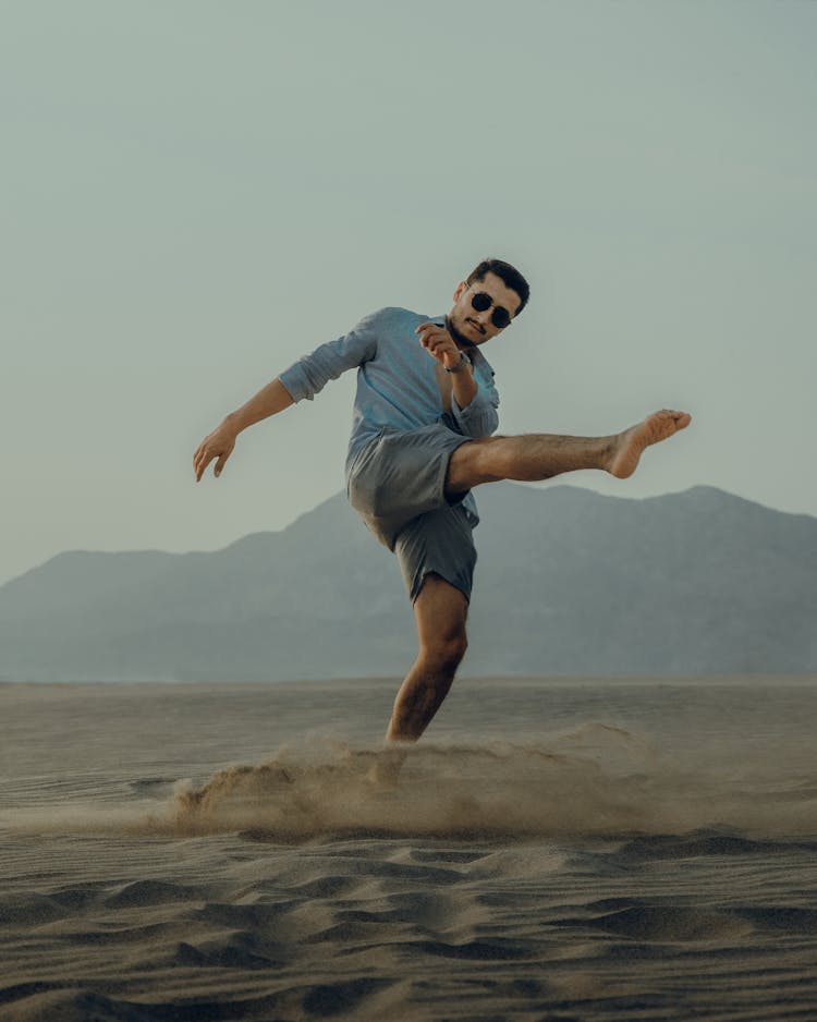 A Man Kicking The Sand