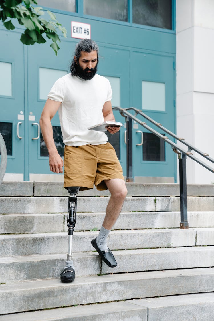Man With Prosthetic Limb Walking Down The Stairs 