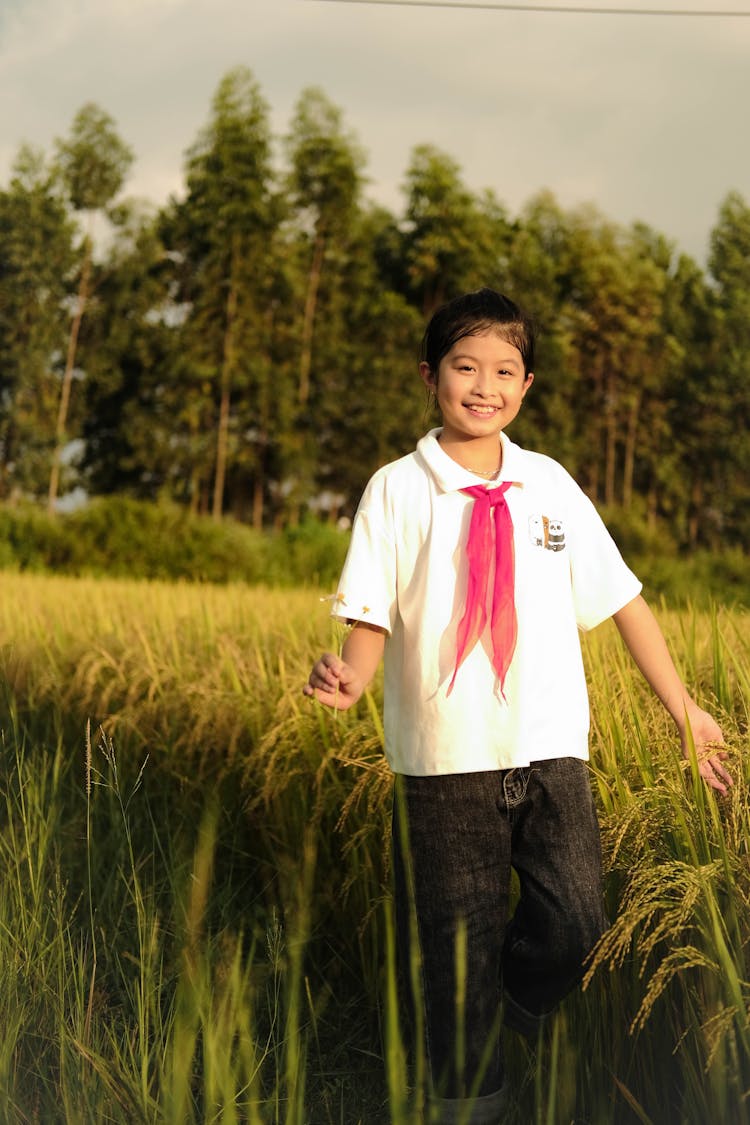 Young Girl In School Uniform Walking On Rice Field