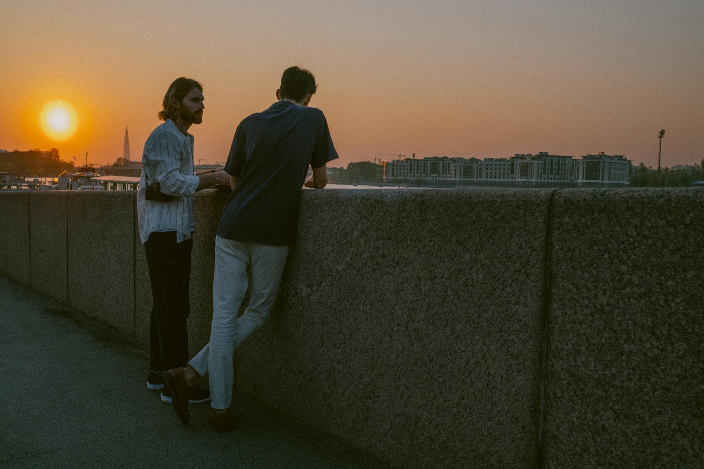 Two Men Standing Beside the Concrete Railing
