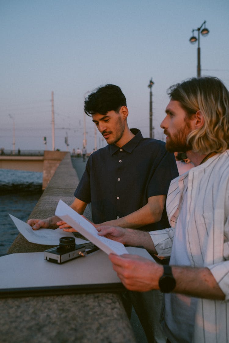 Men Holding Documents On A Bridge