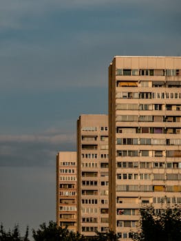 Vertical shot of high-rise concrete apartment buildings against a twilight sky.