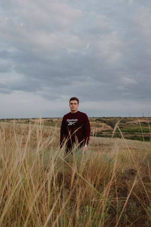 Man Wearing Sweater Standing on Tall Grass