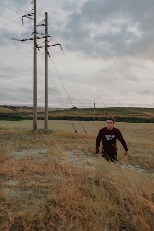 Gratis stockfoto met elektriciteitsmast, kerel, landelijk