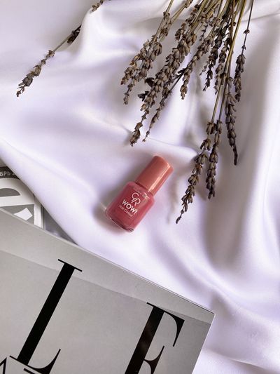 Pink nail polish on white fabric with lavender.