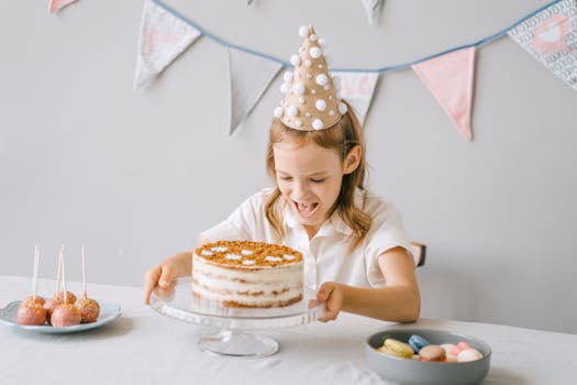 A happy child at a birthday party, ready to enjoy a delicious cake and treats.