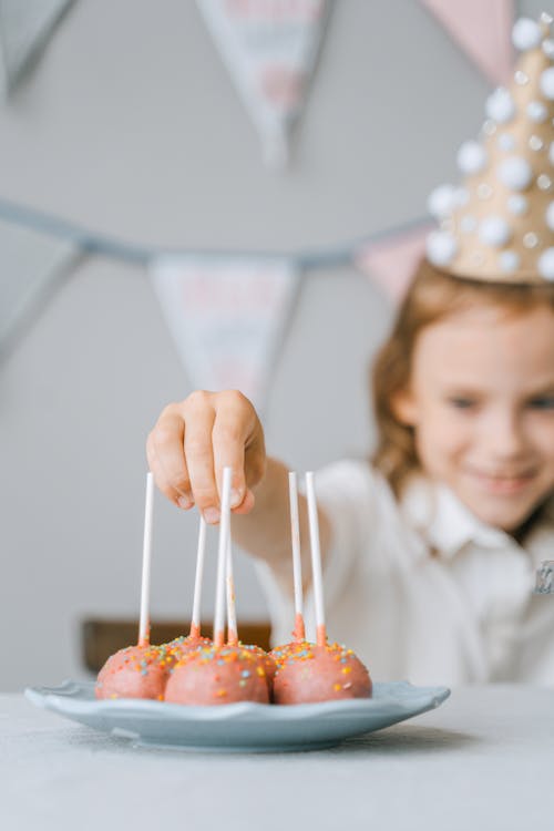 Free A Person Holding a Cake Pop Stock Photo