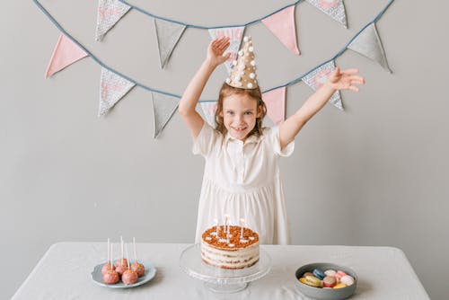 A Girl in White Dress Standing at the Table