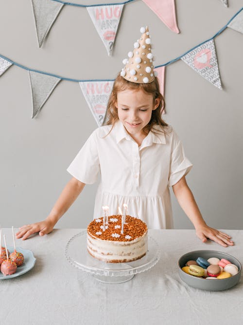 A Young Girl Smiling while Looking at her Birthday Cake