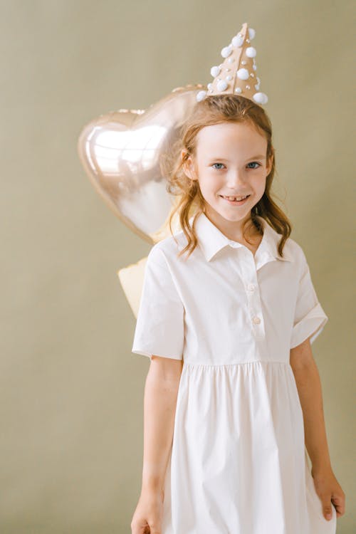 Free Girl in White Button Up Shirt Standing Near White Wall Stock Photo