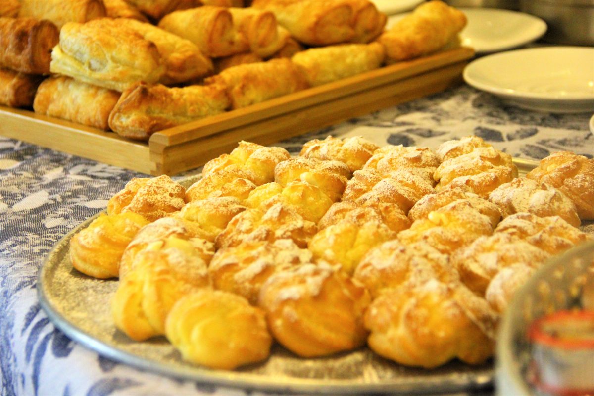 Tantalizing display of fresh pastries topped with powdered sugar on a tray.