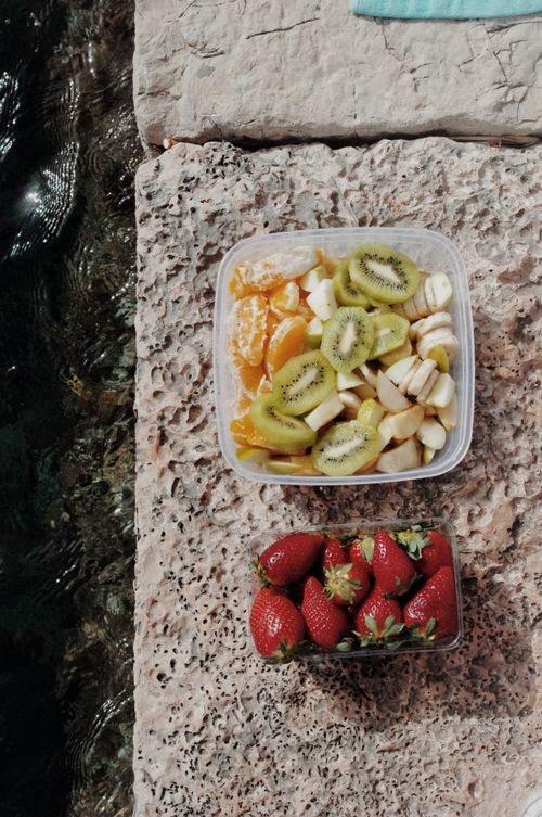 Free Delicious sliced fruits including kiwi, banana, and strawberries by the water in Corfu, Greece. Stock Photo