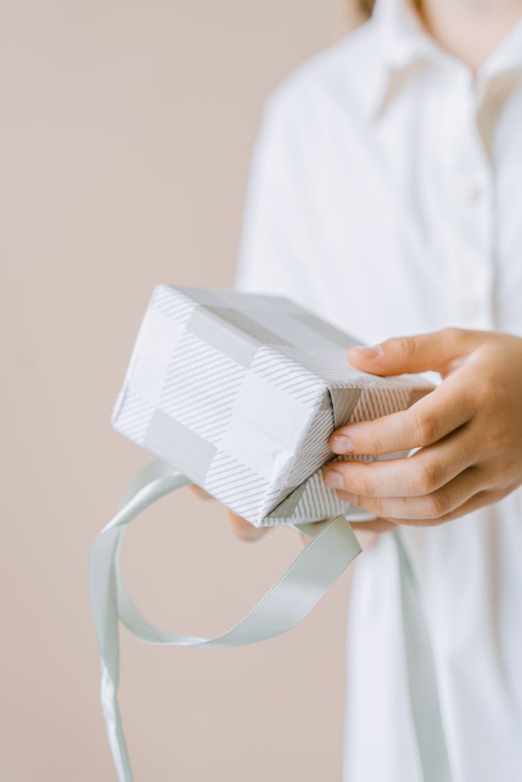 A Person Unwrapping A Gift