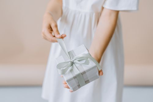 Free Hands holding a gift box with ribbon, perfect for celebrations and special occasions. Stock Photo