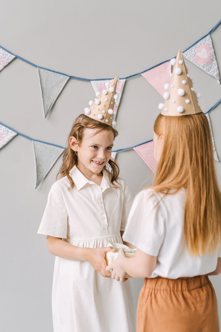 A Young Girl Receiving A Gift From Her Friend