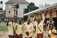 Group of Men in Yellow Uniform Standing on Street