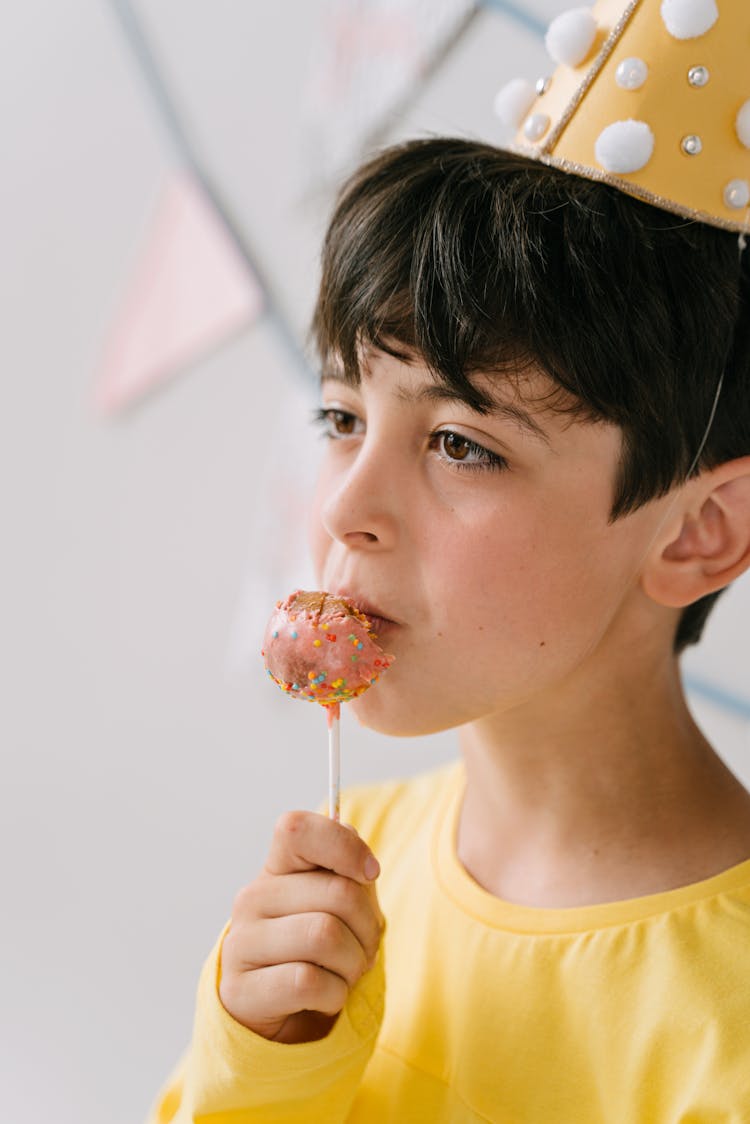 A Young Boy Eating Chocolate Lollipop