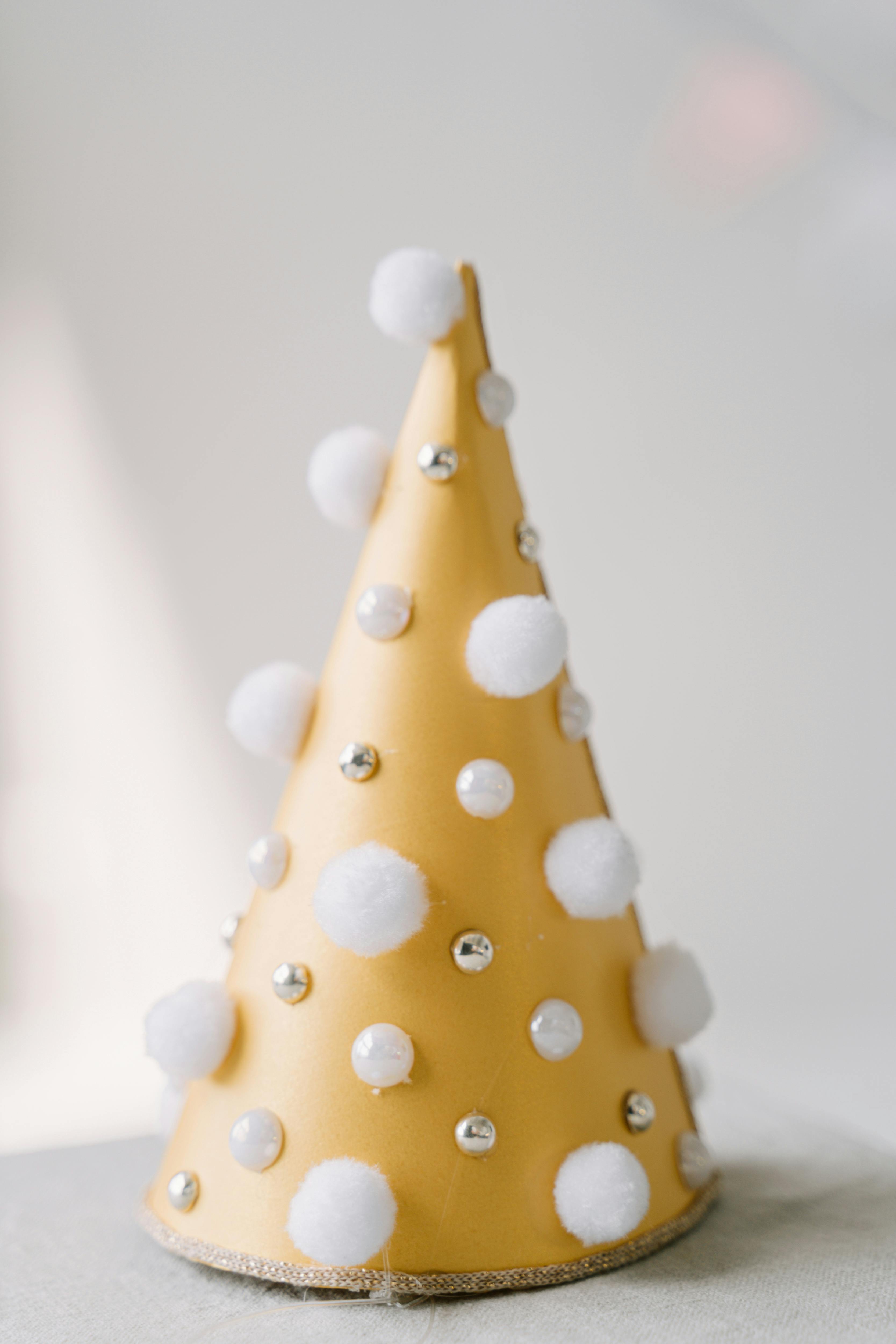 a party hat with silver dots and cotton bals