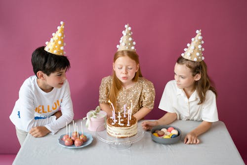 Free A Girl Blowing Candles on a Cake  Stock Photo