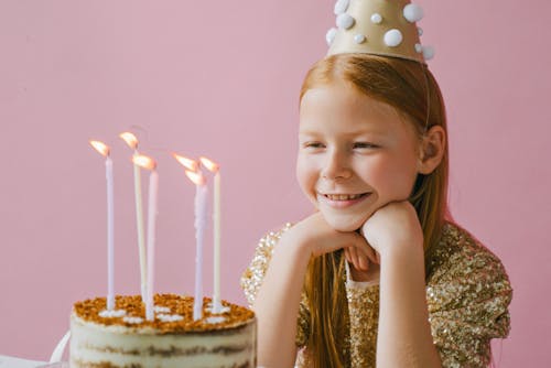 Free Girl Smiling in Front of a Cake Stock Photo