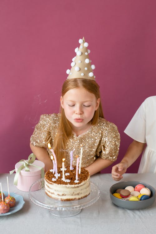 A Girl Blowing the Candles on a Birthday Cake 