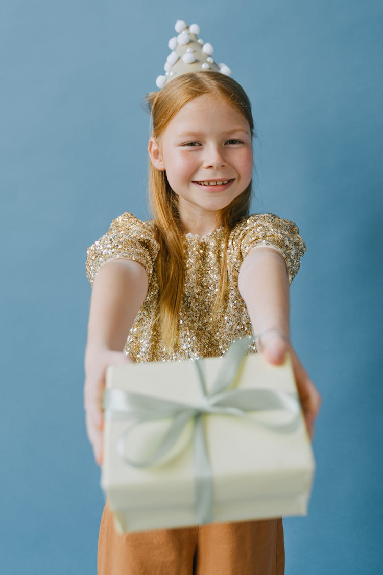 Smiling Girl With Party Hat Holding A Gift 