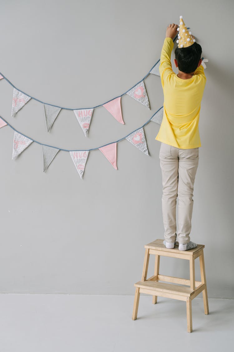 A Person Hanging A Birthday Banner