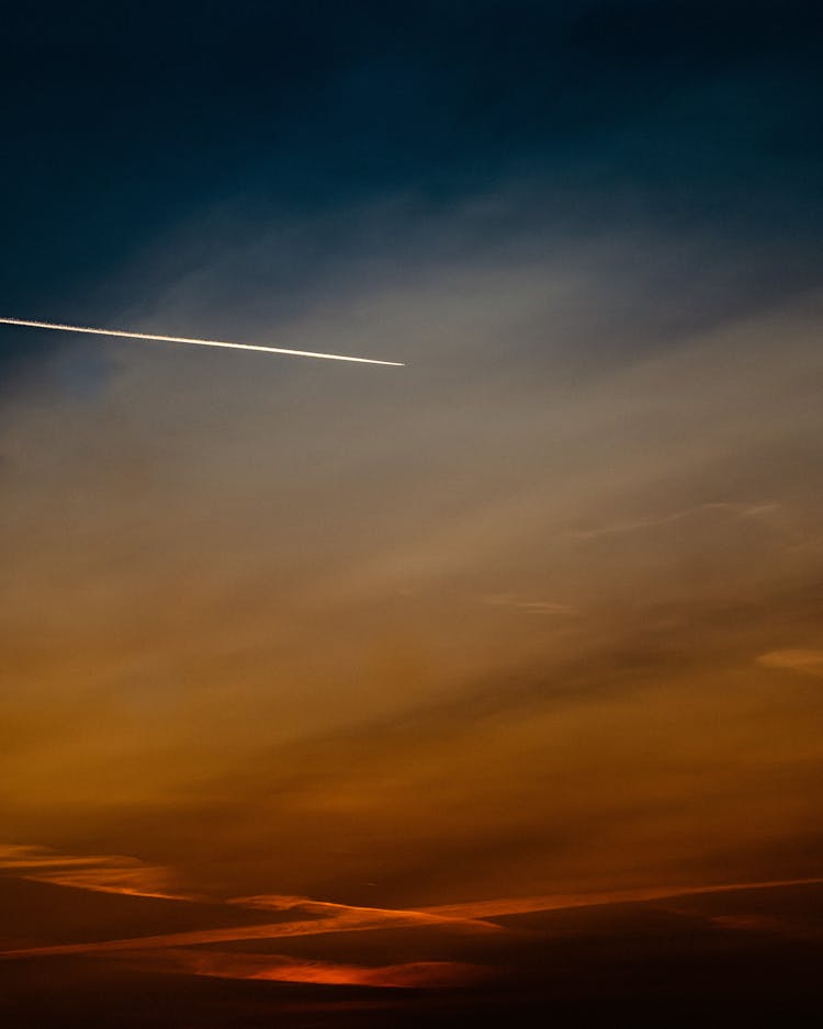 Plane Flying In Sky On Sunset