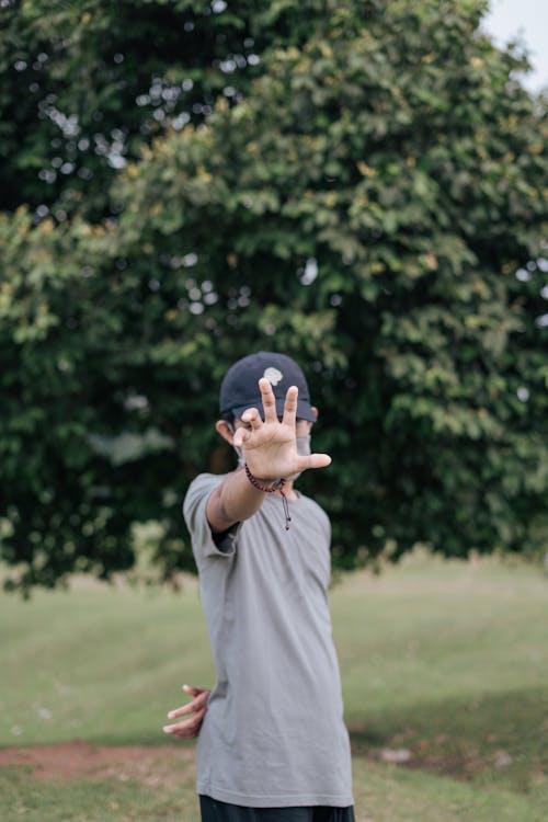 Man in Gray Shirt Doing Hand Gesture