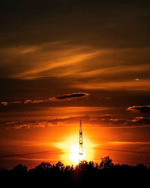 Free A stunning sunset featuring a silhouetted tower against vibrant orange clouds, showcasing nature's beauty. Stock Photo