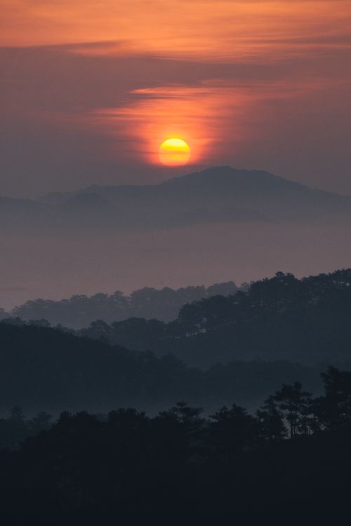 Free Captivating sunrise over misty mountains in Dalat, Vietnam, showcasing nature's beauty and serenity. Stock Photo