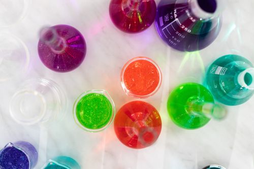 Free Aerial view of colorful liquids in laboratory glassware on marble surface, showcasing vibrant hues. Stock Photo