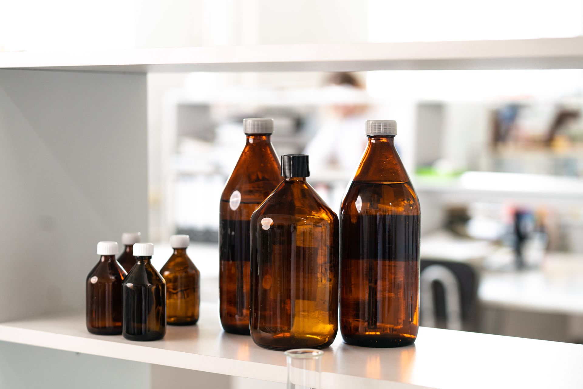 Medicine bottles lined up on a pharmacy shelf