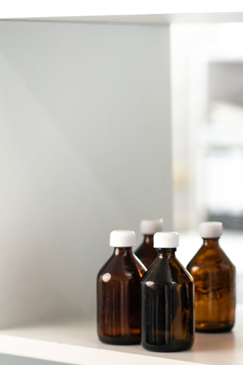 Free Brown Glass Bottle on White Table Stock Photo